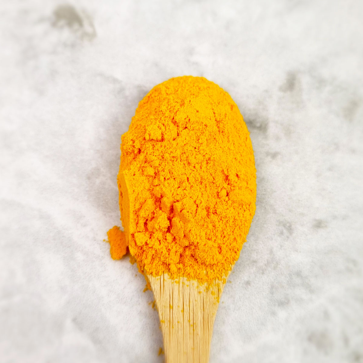 Curcumin powder in a bright yellow shade, natural food coloring for creative culinary applications.