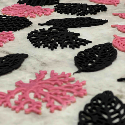 Yes superfood Black and pink decorative tuile leaves on a textured surface