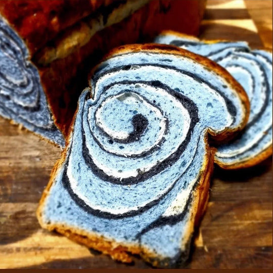 Close-up of sliced bread with blue and white swirl pattern on a wooden surface