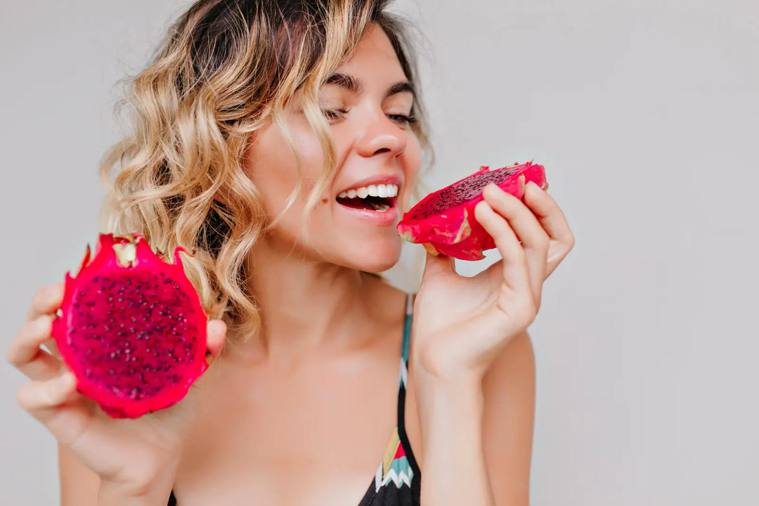 A woman holding a halved dragon fruit in her hands – vibrant, exotic and naturally colorful. Brand visual for Yes Superfood About Us page.
