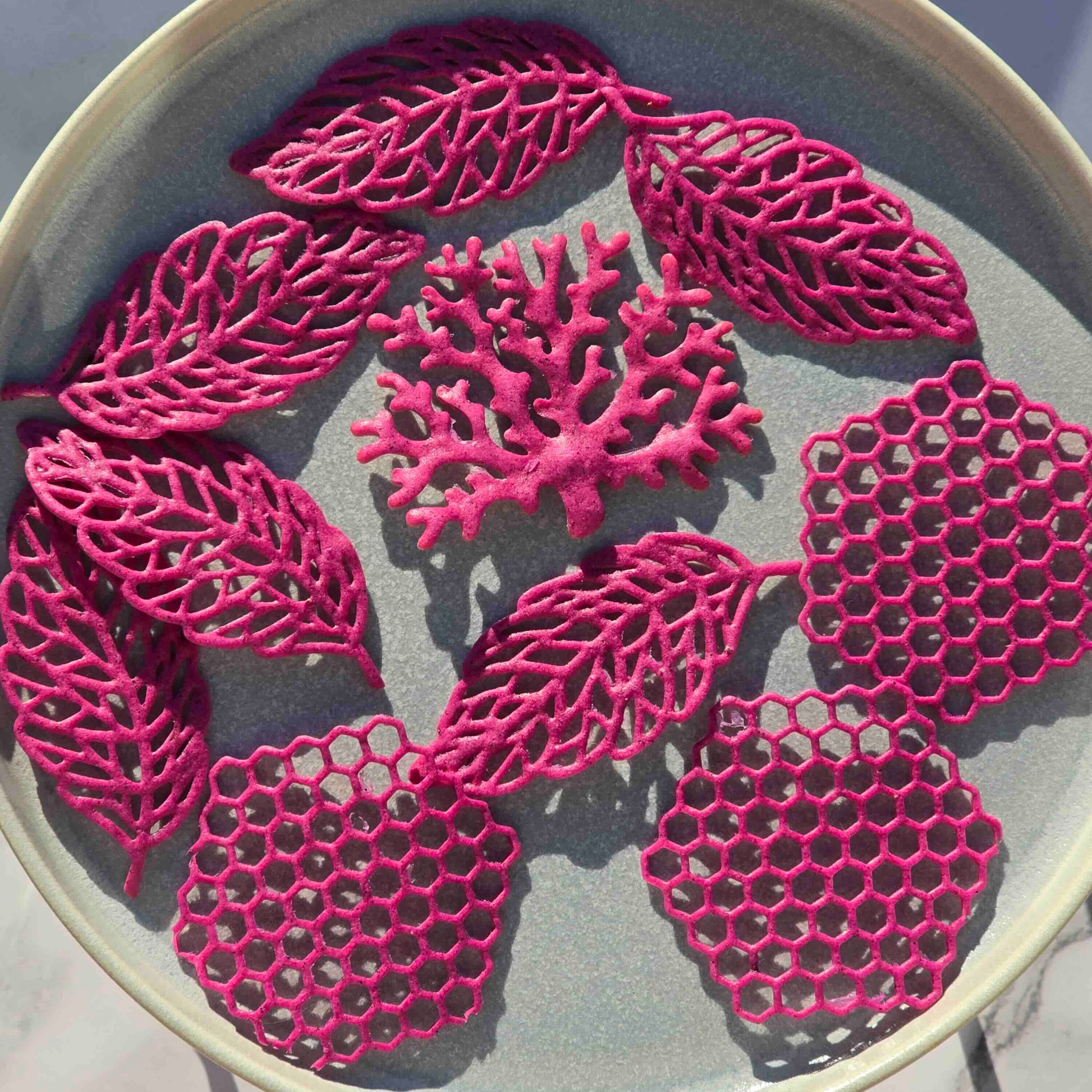 Embroidery hoop with pink leaf patterns on a light background