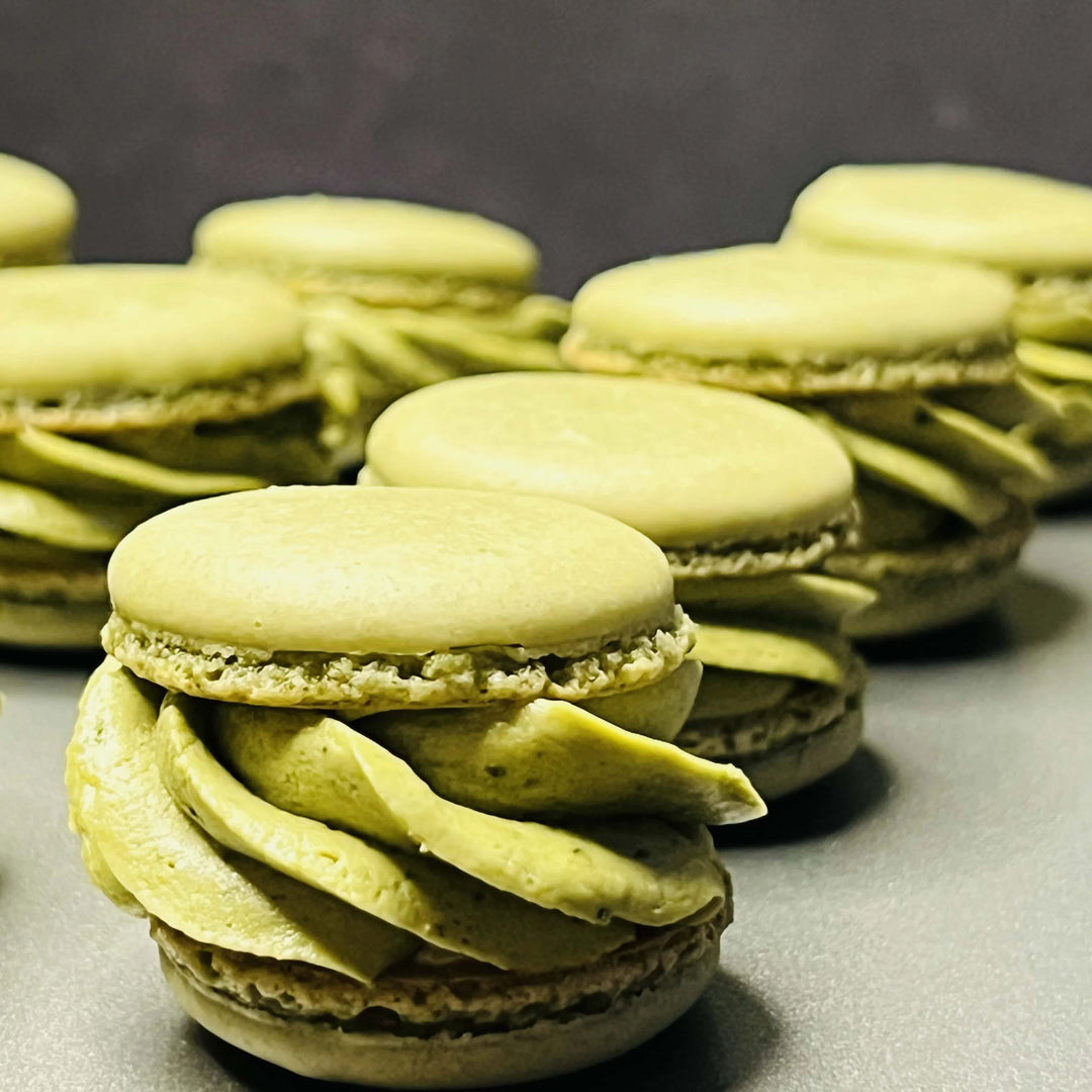 Matcha green macarons with creamy matcha filling arranged in a row