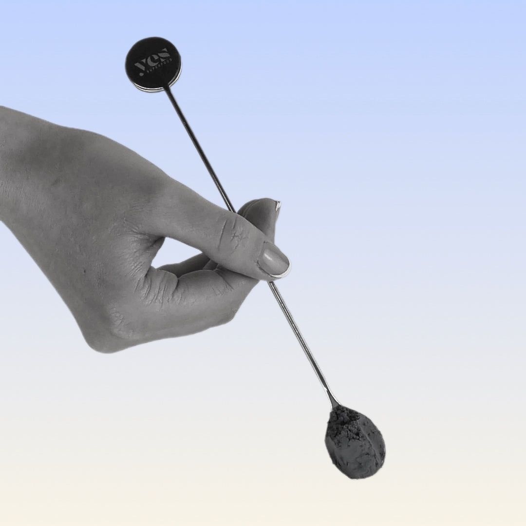 Hand holding Yes Superfood stainless steel mixing spoon with engraved logo