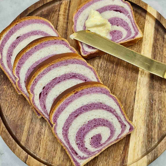 Sliced brioche bread with black carrot powder swirled into the dough, creating natural purple spiral pattern