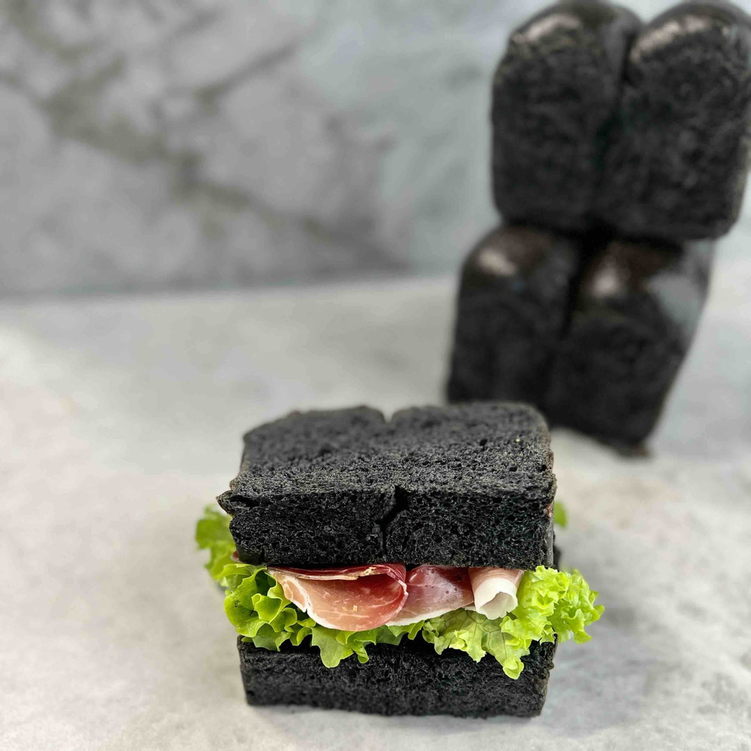 Sandwich made with activated charcoal black bread showing natural black dough coloring