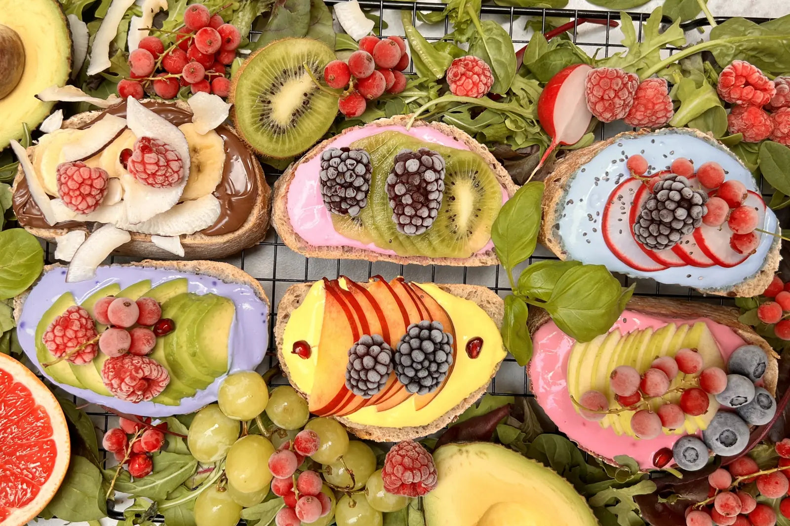 Slice of bread topped with colorful yogurt and fruit – playful breakfast scene using natural superfood powders.